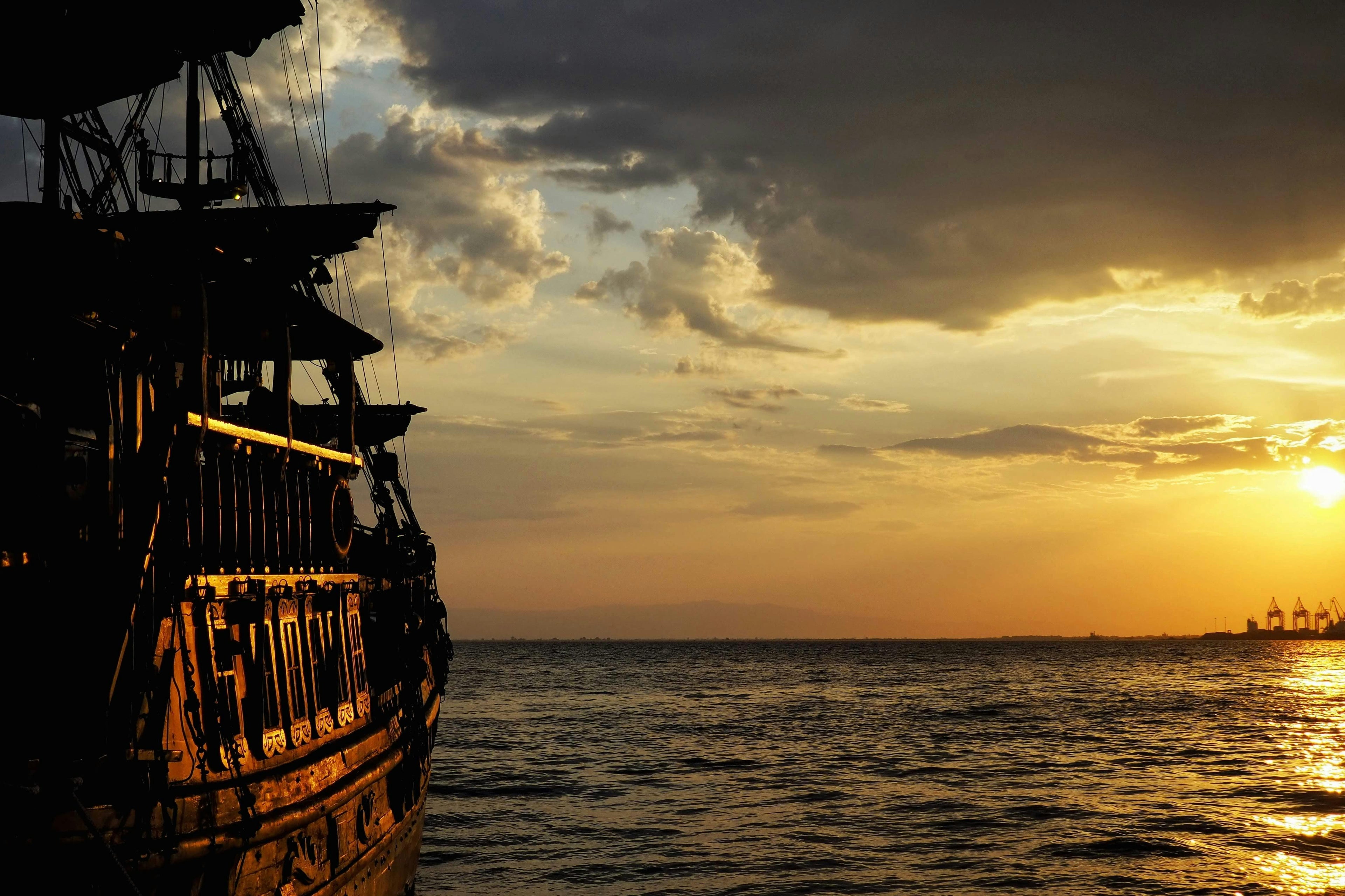 A pirate ship setting off to sail in the sunset
