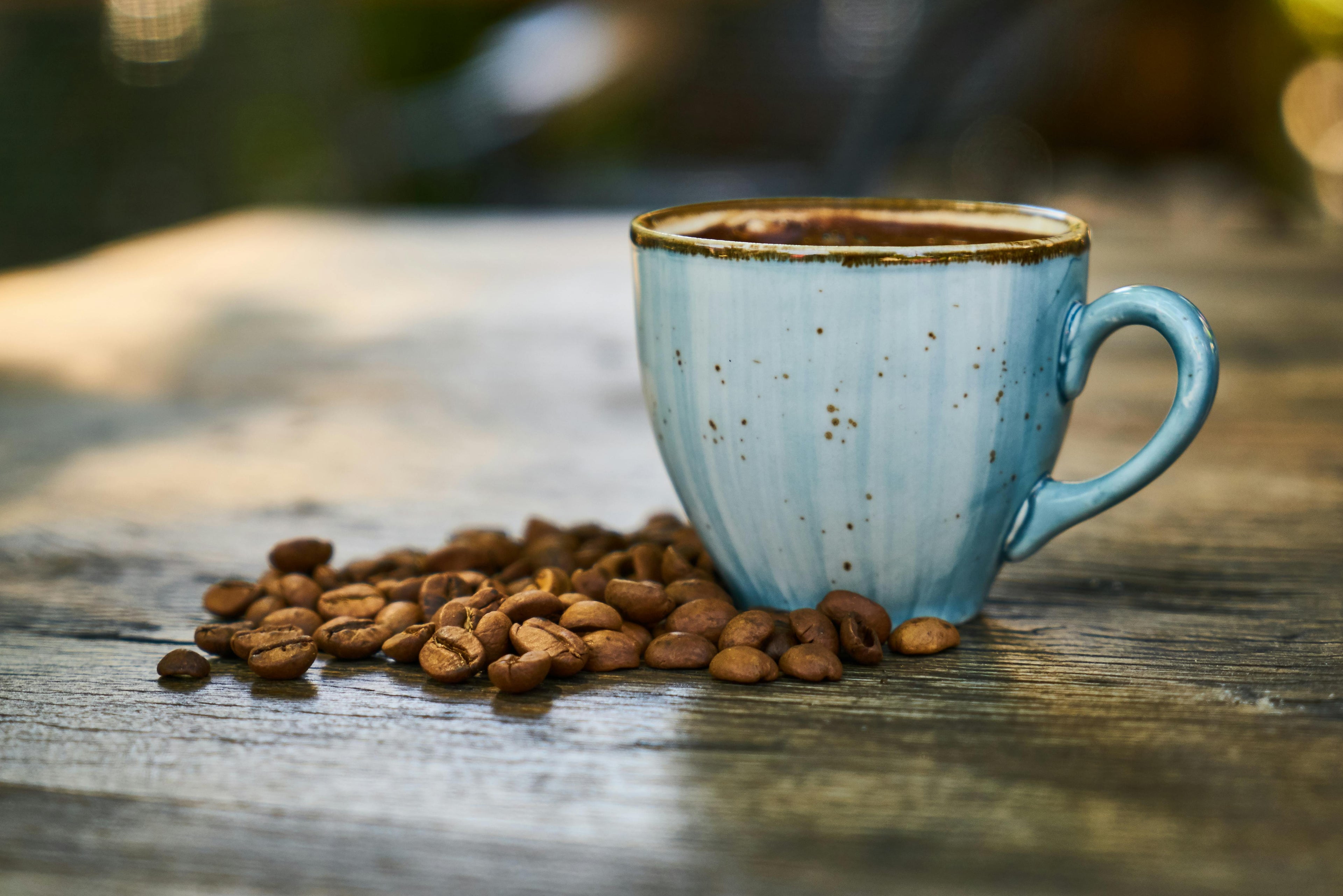 A beautiful cup of coffee with beans sitting on a table