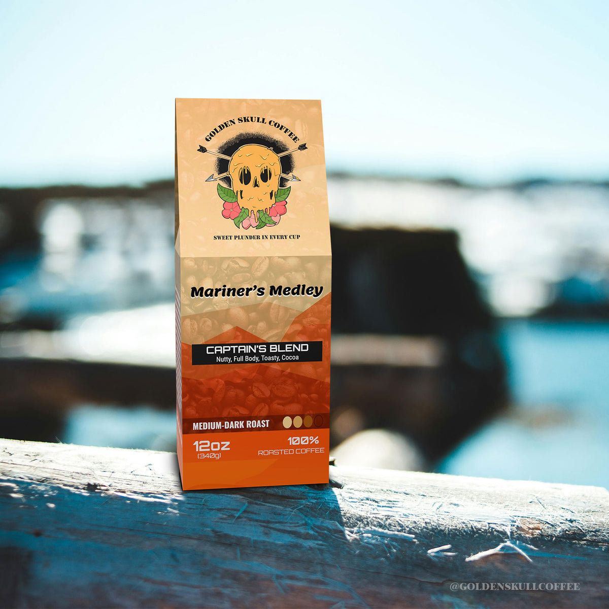 Coffee package labeled 'Mariner's Medley' by Golden Skull Coffee on a wooden surface with a blurred natural background.