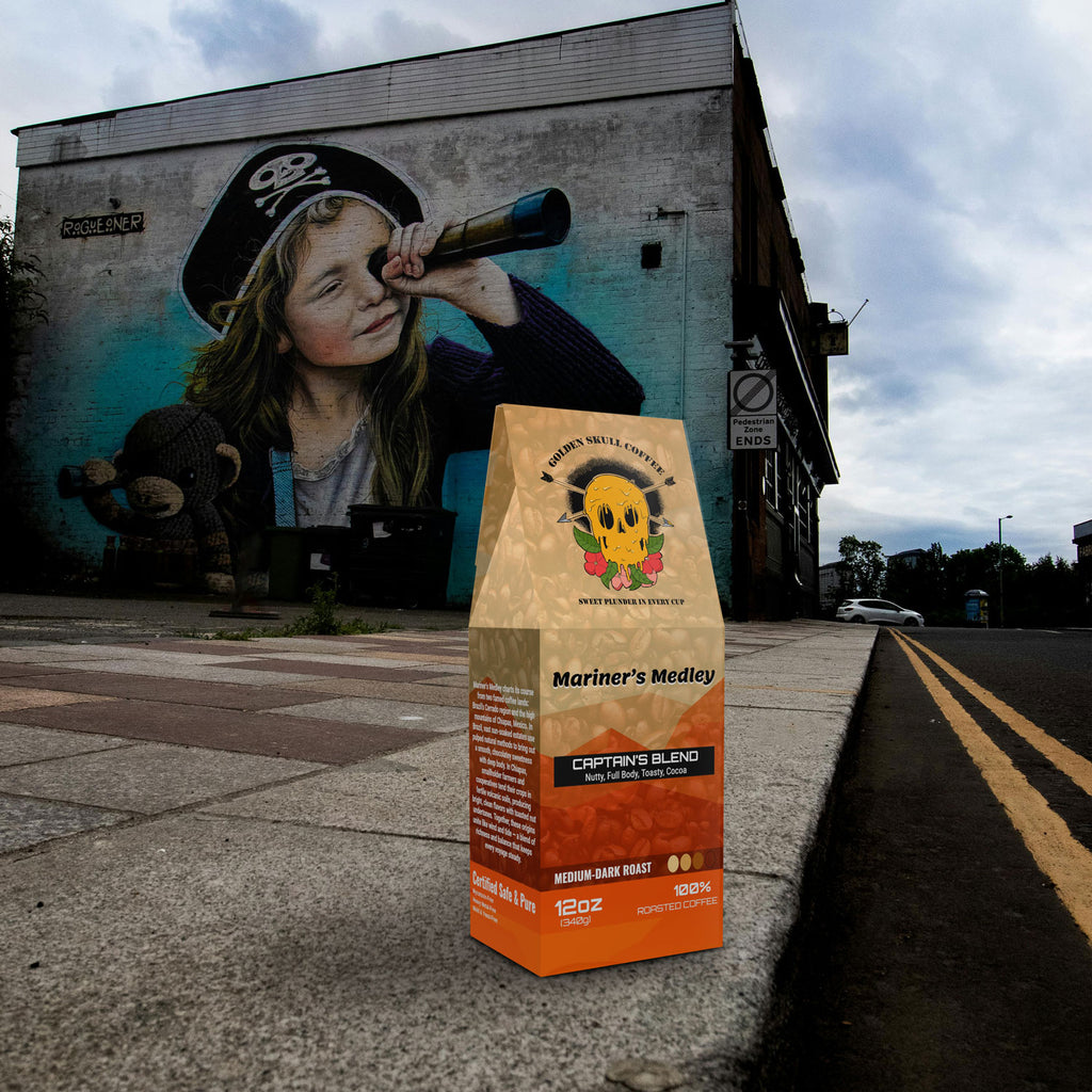 Coffee bag labeled 'Mariner's Medley' on a sidewalk with a mural of a child holding a bottle in the background.